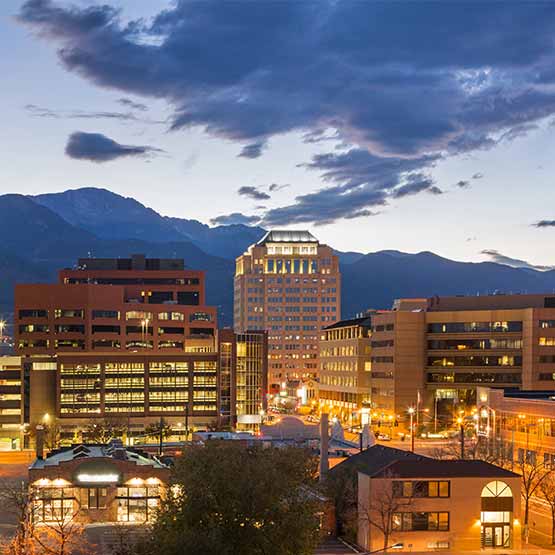 promo_business_sq-2 Evening view of the Colorado Springs city skyline with the mountains in the background